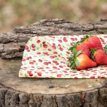 Bivokspapir med jordbærmønster. Ferske jordbær plassert på bivokspapiret.