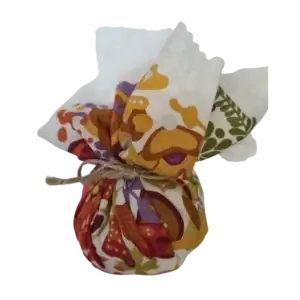 Poleringsball i bomull for påføring av bivoks på møbler og treverk, med et fargerikt mønster på hvit bakgrunn.